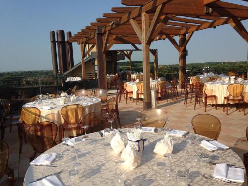 Grand Hotel Forlì في فورلي: مجموعة من الطاولات والكراسي مع قماش الطاولة البيضاء