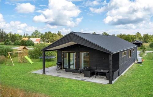 a black shed with a patio and a playground at 3 Bedroom Beautiful Home In Jerup in Jerup