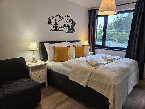a bedroom with a bed with a chair and a window at Mlýn Herlíkovice in Hořejší Vrchlabí