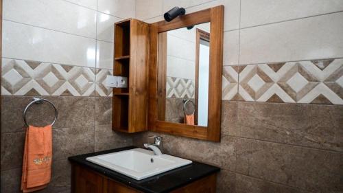 a bathroom with a sink and a mirror at U & S Luxury Apartments Ltd in Quatre Bornes