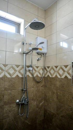 a shower with a shower head in a bathroom at U & S Luxury Apartments Ltd in Quatre Bornes