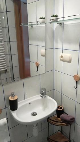a bathroom with a white sink and a mirror at Noclegi Barbara Pietraszek in Krempachy
