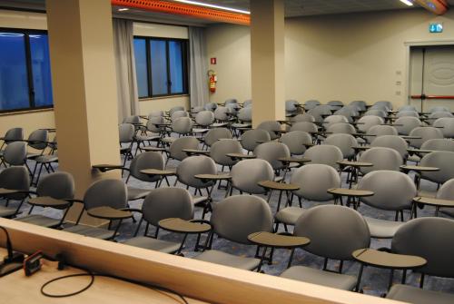 an empty room with chairs and tables in it at Grand Hotel Forlì in Forlì
