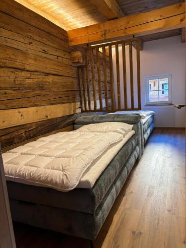 a large bed in a room with wooden walls at Mountain Resort in Rangersdorf