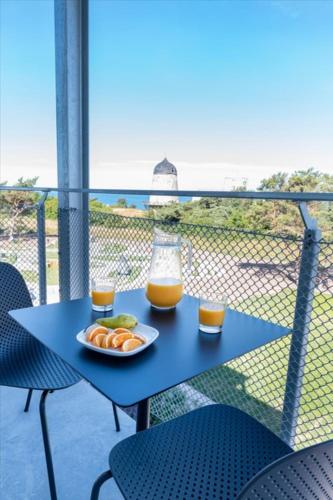 a table with a plate of food and two glasses of orange juice at First Hotel Kokoloko in Visby