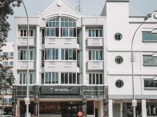 a white building with a sign in front of it at Hi Hotel Dot, 11Hrs, Stay from 10PM to 9AM in Singapore