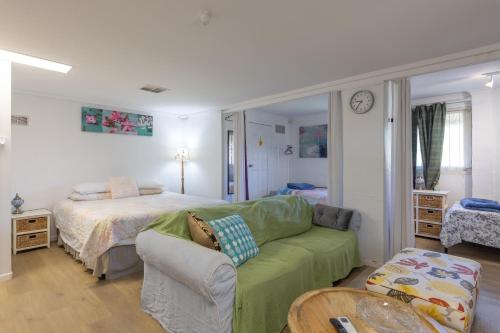 a living room with a bed and a green couch at Zen Escape Guest House " Location 1" - Three listings - Romantic Escape, Cozy Delight, Oasis Suite in Brisbane