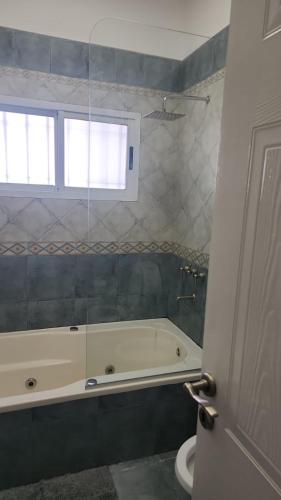 a bathroom with a tub and a toilet and a window at Tigre Centro Cochera Gratis in Tigre