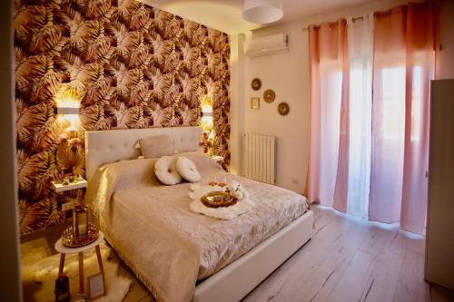 菲乌米奇诺Casa di Alisia的卧室里有一张床，墙上挂着花