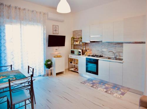 菲乌米奇诺Casa di Alisia的厨房配有白色橱柜、餐桌和用餐室