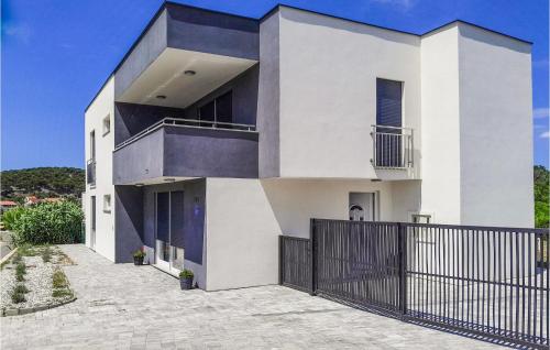a white house with a black fence at Cozy Home In Rab With Wifi in Rab