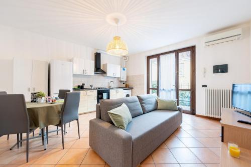 a living room with a couch and a kitchen at Casa Emilia - cozy apartment in Parma in Parma