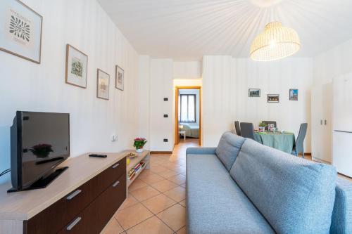a living room with a blue couch and a television at Casa Emilia - cozy apartment in Parma in Parma