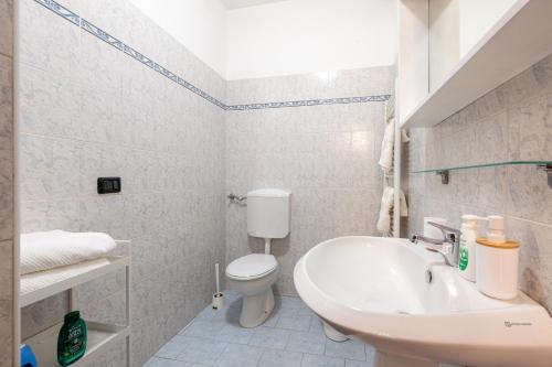 a white bathroom with a toilet and a sink at Casa Emilia - cozy apartment in Parma in Parma