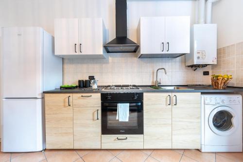 a kitchen with a white refrigerator and a dishwasher at Casa Emilia - cozy apartment in Parma in Parma