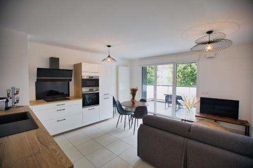 une cuisine et un salon avec un canapé et une table dans l'établissement Le Majuscule, à Annecy