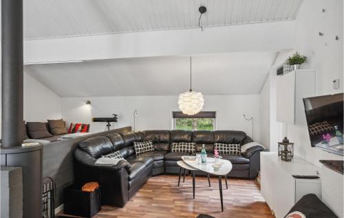 a living room with a leather couch and a table at 4 Bedroom Cozy Home In Brovst in Brovst