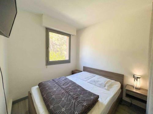 une chambre avec un lit et une fenêtre dans l'établissement Charmant T2 à 1km des plages de Sanary, à Sanary-sur-Mer