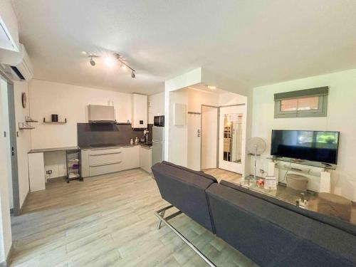 un salon avec un canapé et une cuisine dans l'établissement Charmant T2 à 1km des plages de Sanary, à Sanary-sur-Mer