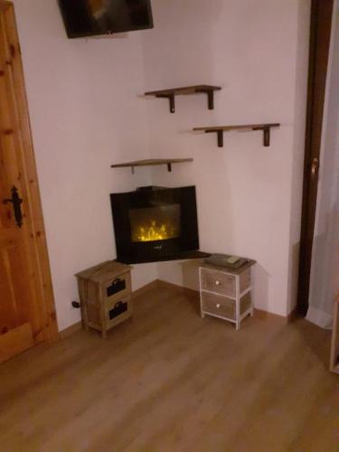 a living room with a fireplace in the corner at monolocale Sabrina in Torgnon
