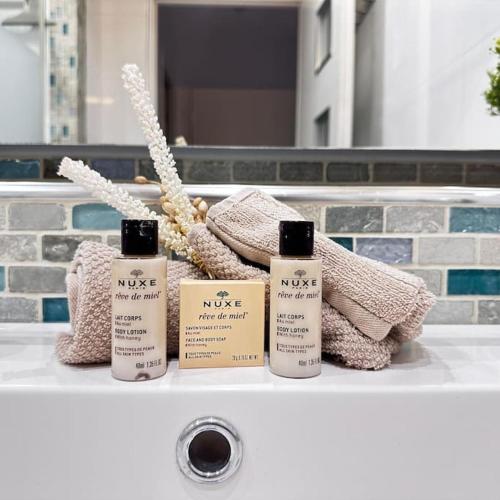 3 bouteilles de nisse assises sur un lavabo dans la salle de bains dans l'établissement Studio premium St Louis - emplacement idéal, à Cannes