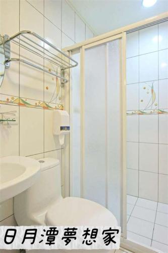 a bathroom with a shower and a toilet and a sink at Sun Moon Lake Dream House B&B in Yuchi