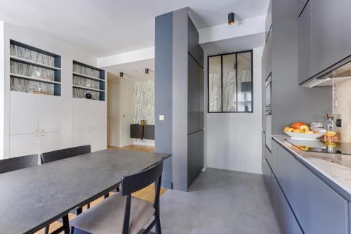une cuisine avec des placards blancs et un grand îlot dans l'établissement Luxury apartment at heart of Paris, à Paris