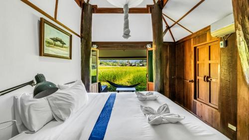 a bed in a room with a window at Buzzas @ Pai Chan in Pai