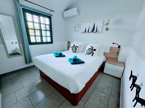 a bedroom with a bed with blue towels on it at VV Sweet Flamboyan Playaflor 1 "by henrypole home" in Maspalomas