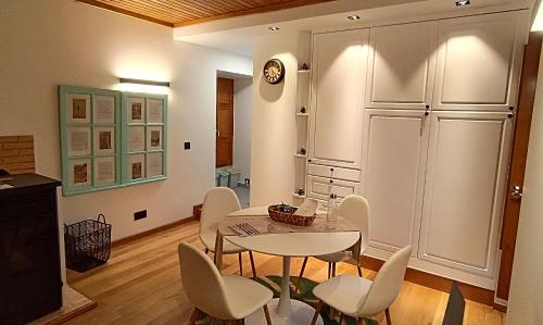 a dining room with a table and white chairs at Golden Mountain, Nature House in Manteigas