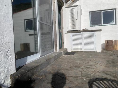 a door of a house with a window and a stone patio at House with Forest View in Lajes das Flores