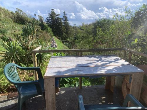 a wooden table and chairs sitting on a balcony at House with Forest View in Lajes das Flores