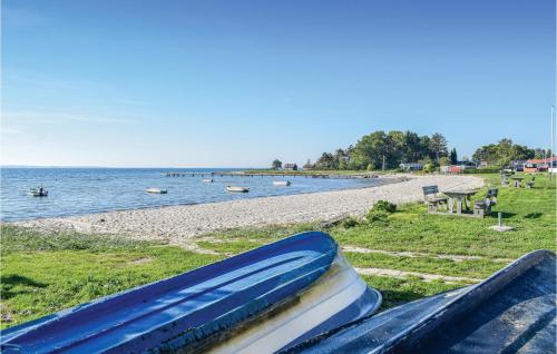 a stack of books sitting on a bench next to a beach at Holiday Home Valmuevej Rønde Ix in Rønde