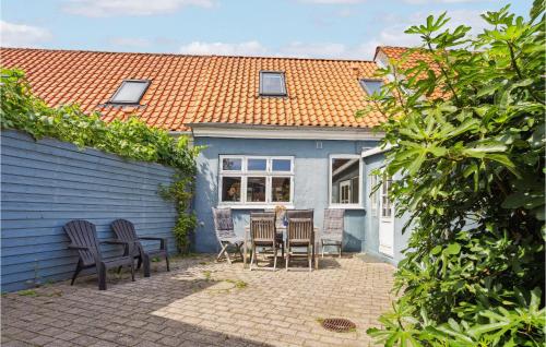 a patio with chairs and a table in front of a blue house at Cozy Home In Assens With Wifi in Assens