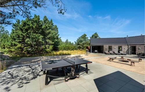 a ping pong table in the middle of a patio at Nice Home In Blåvand With Kitchen in Blåvand