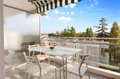 une table blanche et des chaises sur un balcon avec vue dans l'établissement Le Radieux - Spacious - Bright - Car park - Peaceful, à Antibes