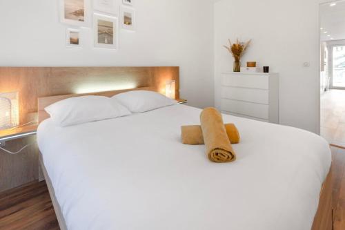 a bedroom with a white bed with two towels on it at Le Radieux - Spacious - Bright - Car park - Peaceful in Antibes