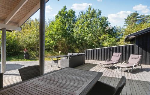 a deck with chairs and a table and a table and chairs at Holiday Home Hægvej Grenaa Xi in Grenå