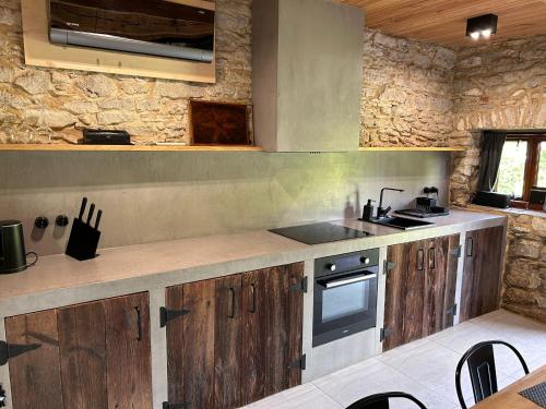 a kitchen with wooden cabinets and a stove top oven at AleChatki Roztocze in Huta Lubycka