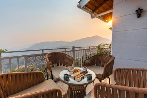 a balcony with chairs and a table with food on it at Alaya Stays 2 BHK Villa With Scenic views - Peace in Bhīm Tāl