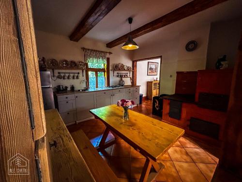 a kitchen with a table with a vase of flowers on it at AleChatki Roztocze in Huta Lubycka