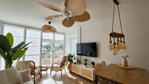 Una sala de estar con una mesa y un ventilador de techo. en Boho Arenal Bol, en Calpe