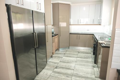 a kitchen with a refrigerator and a tile floor at Hermanus Reefs in Hermanus