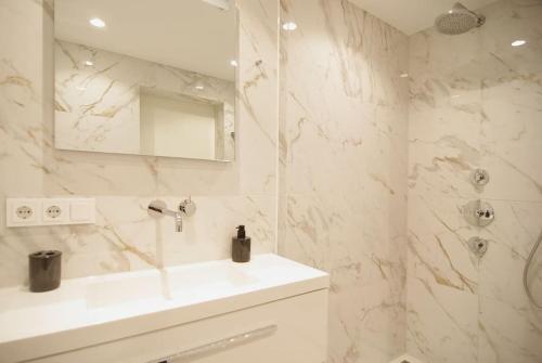 a white bathroom with a sink and a mirror at Spacious Suite at Park and Museum in Amsterdam
