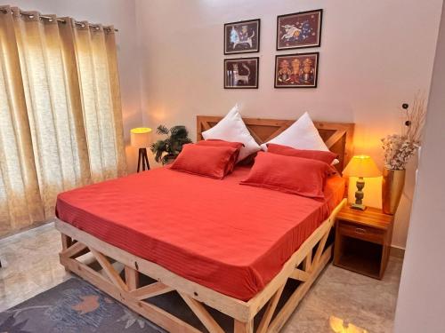 a bedroom with a large wooden bed with red pillows at Vasantvasoj Homestay in Pauri
