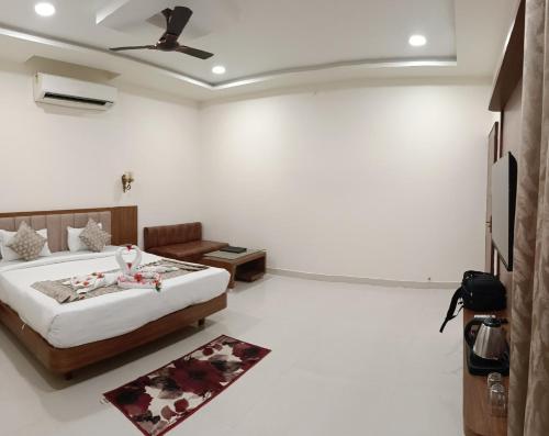 a bedroom with a bed and a couch in it at Hotel Royal Palace in Sāgar