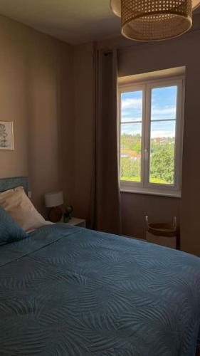 une chambre avec un lit bleu et une fenêtre dans l'établissement Gite Le 38 à Goetzenbruck, chez Barbara, 53m2, à Goetzenbruck