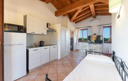 a kitchen with white cabinets and a white refrigerator at Vignola Baia Dei Mirti M3 in Vignola Mare