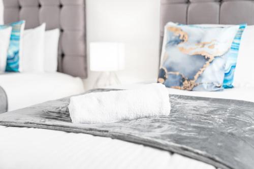 a white bed with a towel on top of it at Two Bedroom Apartment - Parking - Sleeps 3 - Fast WiFi - Netflix - Top Rated - 27BC in Sleightholme