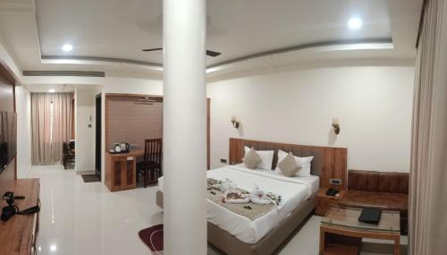 a bedroom with a bed and a living room at Hotel Royal Palace in Sāgar